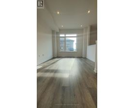 A room with wooden flooring and a large window.