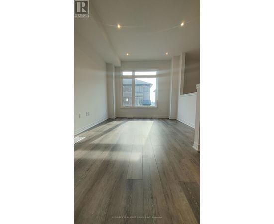 A room with wooden flooring and a large window.