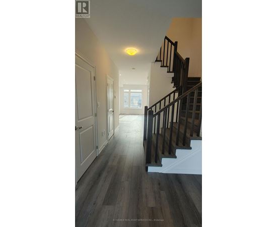 A hallway with a staircase and a light on the ceiling.
