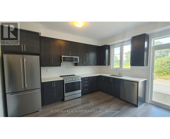 A kitchen with black cabinets and stainless steel appliances.