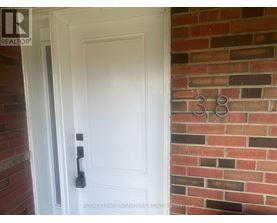 A white door with a black handle is set in a brick wall.
