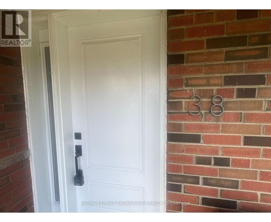A white door with a black handle is set in a brick wall.