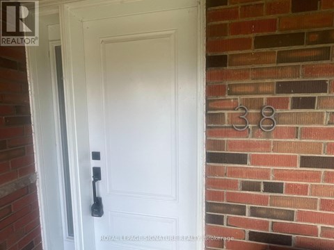 A white door with a black handle is set in a brick wall.