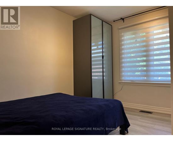 A bedroom with a bed, a window with blinds, and a sliding door.