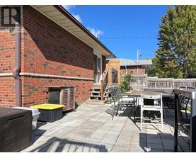 A patio with a table and chairs is in front of a brick building.