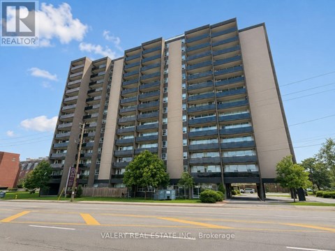 A tall building with many windows is the main focus of the image.