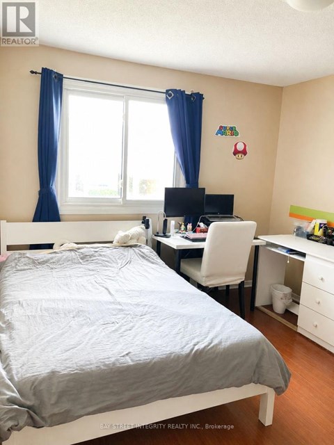 A bedroom with a bed, desk, and chair.