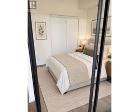 A bedroom with a large bed and a mirror on the wall.