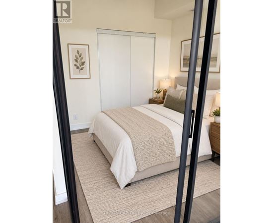 A bedroom with a large bed and a mirror on the wall.