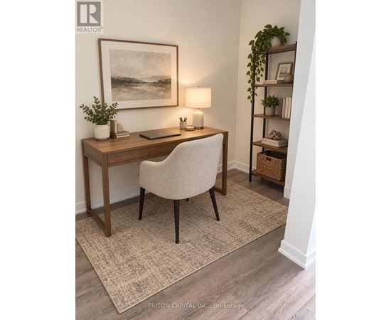 A room with a desk, chair, and a painting on the wall.