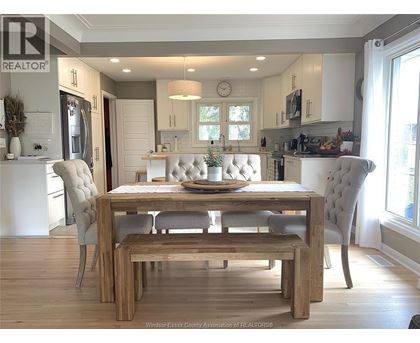 A dining room with a wooden table and chairs.