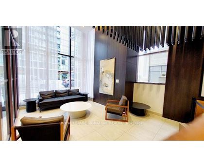 A living room with a couch, chair, and a painting on the wall.