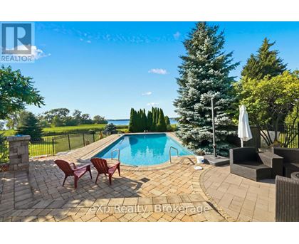 A pool surrounded by a patio and chairs.