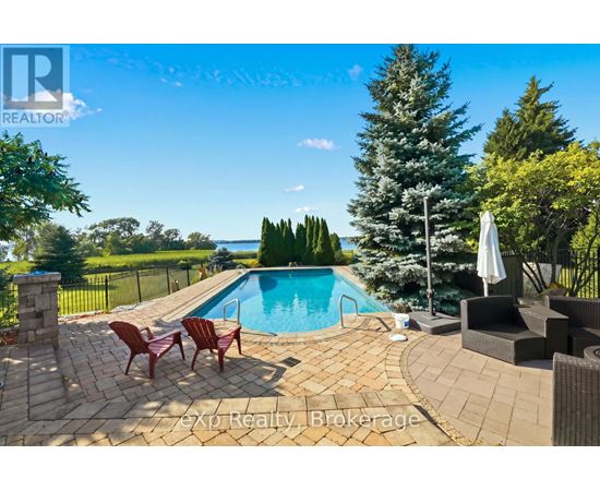 A pool surrounded by a patio and chairs.