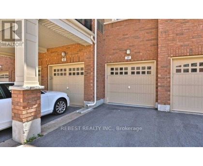 A white car is parked in front of a garage door.