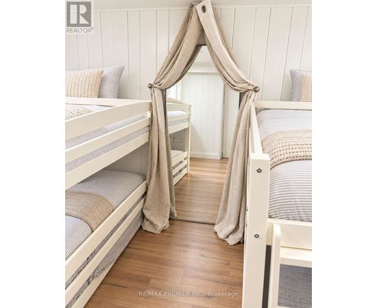 A white bunk bed with a canopy and a striped pillow.