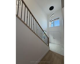 A staircase with a black railing and a light hanging from the ceiling.