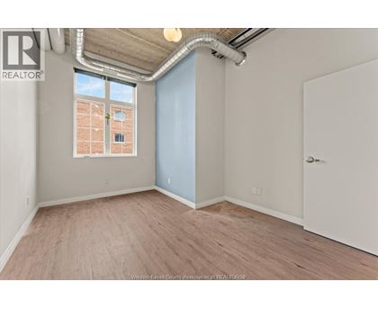 A room with a window and a door is available for rent.