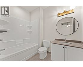 A white bathroom with a toilet, sink, and bathtub.