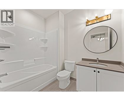 A white bathroom with a toilet, sink, and bathtub.