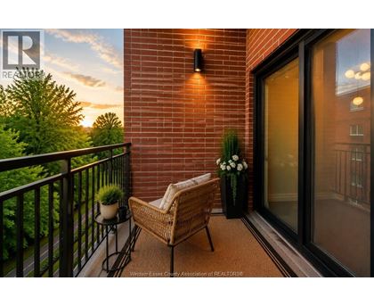 A balcony with a chair and a table with flowers on it.