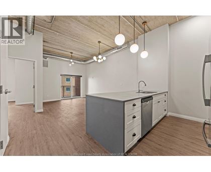 A kitchen area with a white counter and grey cabinets.