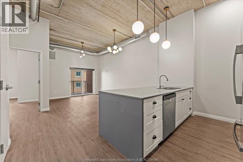 A kitchen area with a white counter and grey cabinets.