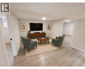 A living room with a grey couch, a brown coffee table, and a flat screen TV mounted on the wall.