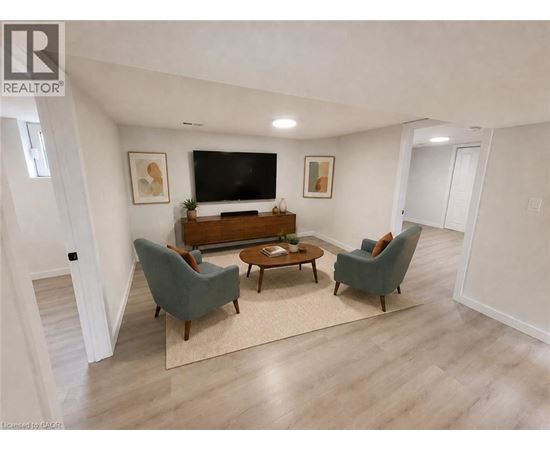 A living room with a grey couch, a brown coffee table, and a flat screen TV mounted on the wall.