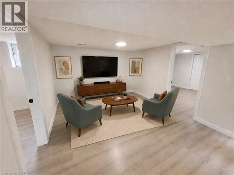 A living room with a grey couch, a brown coffee table, and a flat screen TV mounted on the wall.