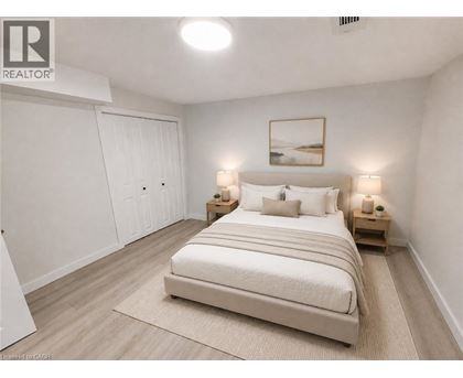 A bedroom with a large bed, two nightstands, and a painting on the wall.