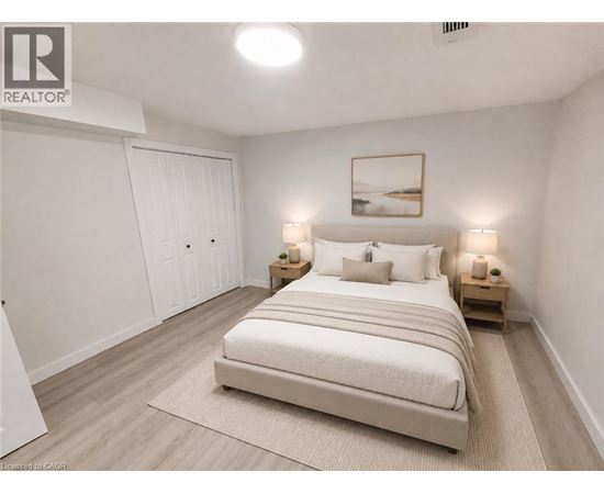 A bedroom with a large bed, two nightstands, and a painting on the wall.