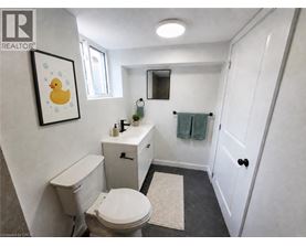 A bathroom with a toilet, sink, and mirror.