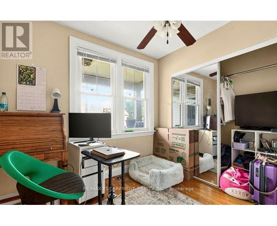 A room with a green chair and a desk with a computer on it.