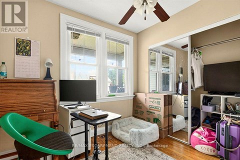 A room with a green chair and a desk with a computer on it.