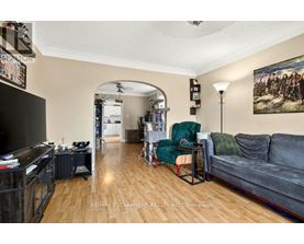 A living room with a grey couch, a green chair, and a painting on the wall.