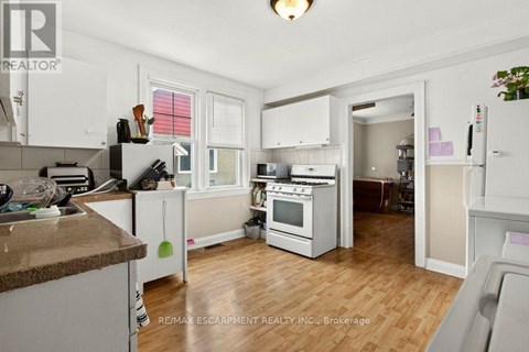 A kitchen with white cabinets and a brown countertop.