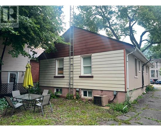 A house with a red roof and a patio table with chairs.