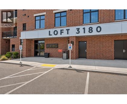 A brick building with a sign that says "LOFT 3180" in front of it.