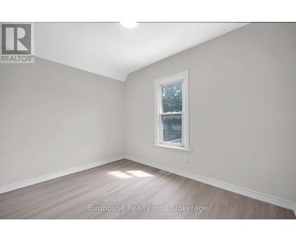 A room with a window and wooden flooring.