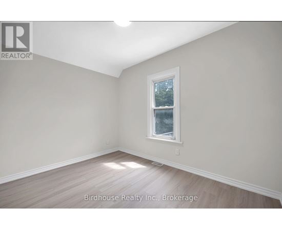 A room with a window and wooden flooring.