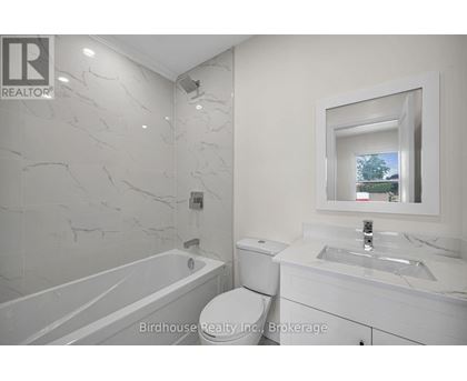 A bathroom with a marble wall and a large mirror.