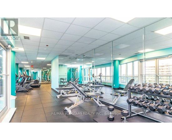 A gym with a variety of equipment including treadmills, weights, and exercise machines.