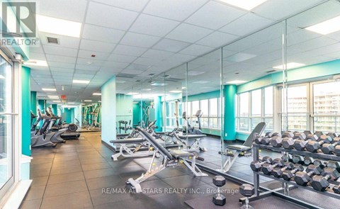 A gym with a variety of equipment including treadmills, weights, and exercise machines.
