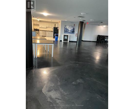 A large open space with a kitchen area in the background.