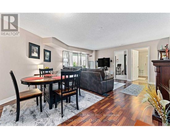 A dining room with a table set for two and a couch.