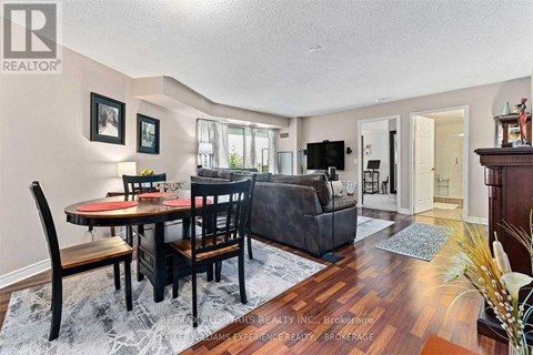 A dining room with a table set for two and a couch.