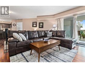 A brown leather couch with a wooden coffee table in front of it.