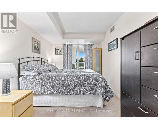 A bedroom with a bed, nightstand, and a dresser.