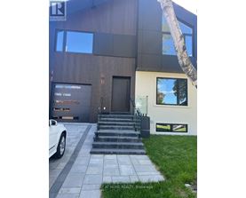 A modern house with a white car parked in front.